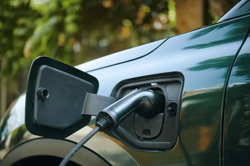 Coche eléctrico cargando en punto de recarga doméstico, ejemplo de actuación que puede generar certificados de ahorro energético (CAE) y valor económico en 2026.